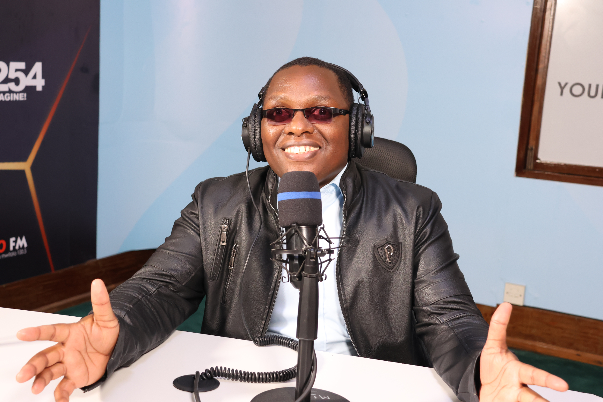 CG Moses wearing headphones and speaking into a studio microphone while recording The Xclusively Inclusive Show at Vuka Studios.